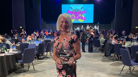 Image shows Aisling smiling with her Lifetime Achievement Award