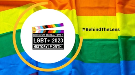 image shows the behind the lens logo with the Pride flag behind it