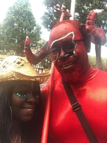 image shows two people smiling in costumes