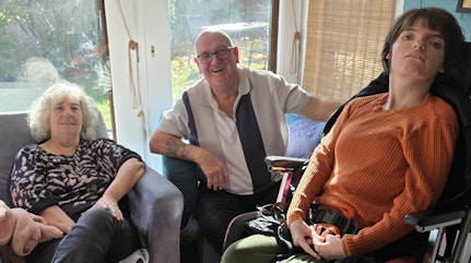 Image shows family smiling at the camera