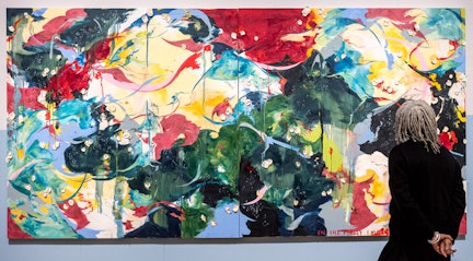 Image shows a person looking at a large piece of artwork